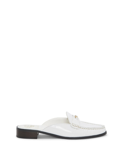 Introducing the Cobby Mule from Vince Camuto—a chic white patent leather loafer featuring a moc toe with detailed stitching, a decorative metal accent on the upper front, and a stylish brown low block heel.