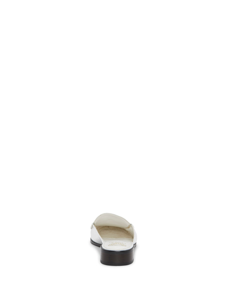 The Vince Camuto Cobby Mule, a white slip-on loafer with a low block heel, is shown from the back and centered on a plain white background.