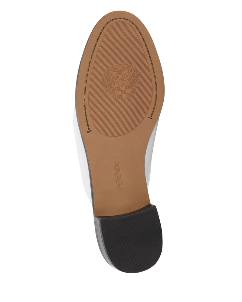 Shoe sole with a tan and black design, featuring a textured section, crest emblem, and a small rectangular label near the arch—perfectly complementing the classic silhouette and low block heel of the Vince Camuto Cobby Mule.