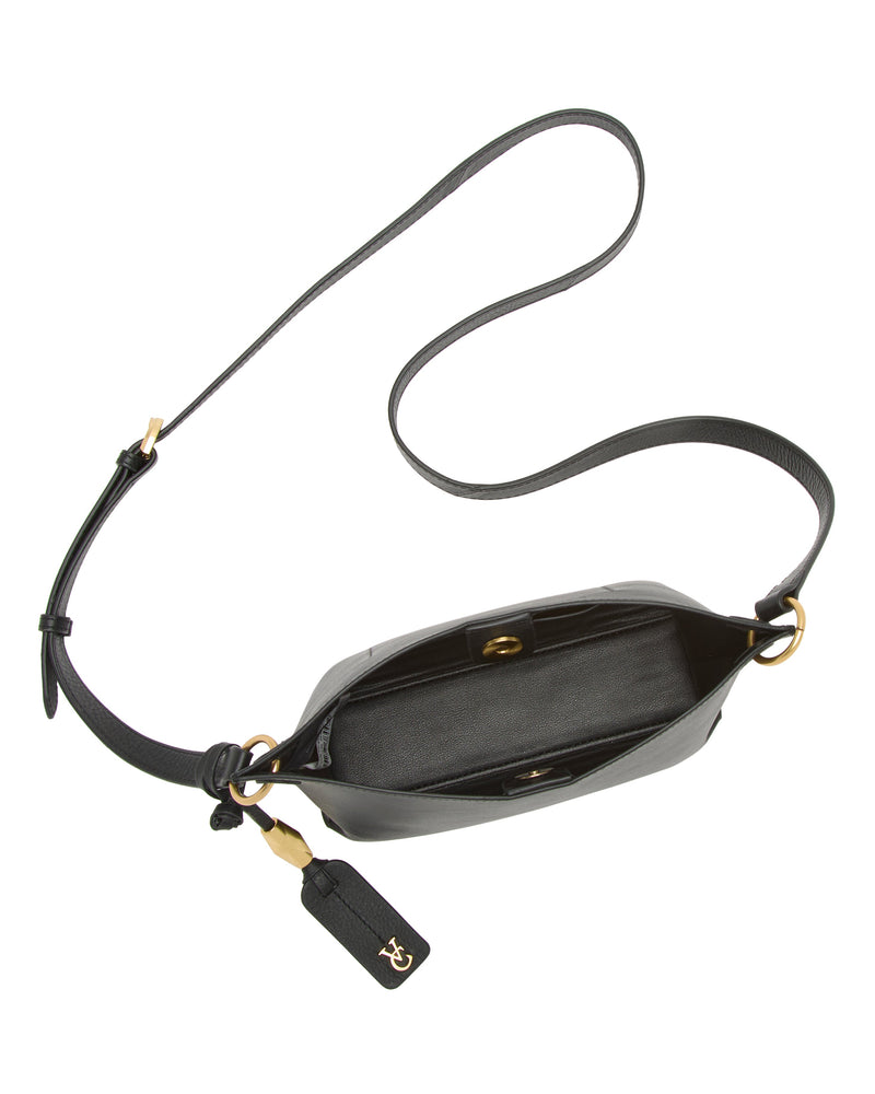 The Vince Camuto Ellah Crossbody Bag features black leather, a long adjustable strap, gold hardware, and an open top with a spacious interior. A leather tag with gold initials hangs from one of the strap rings.