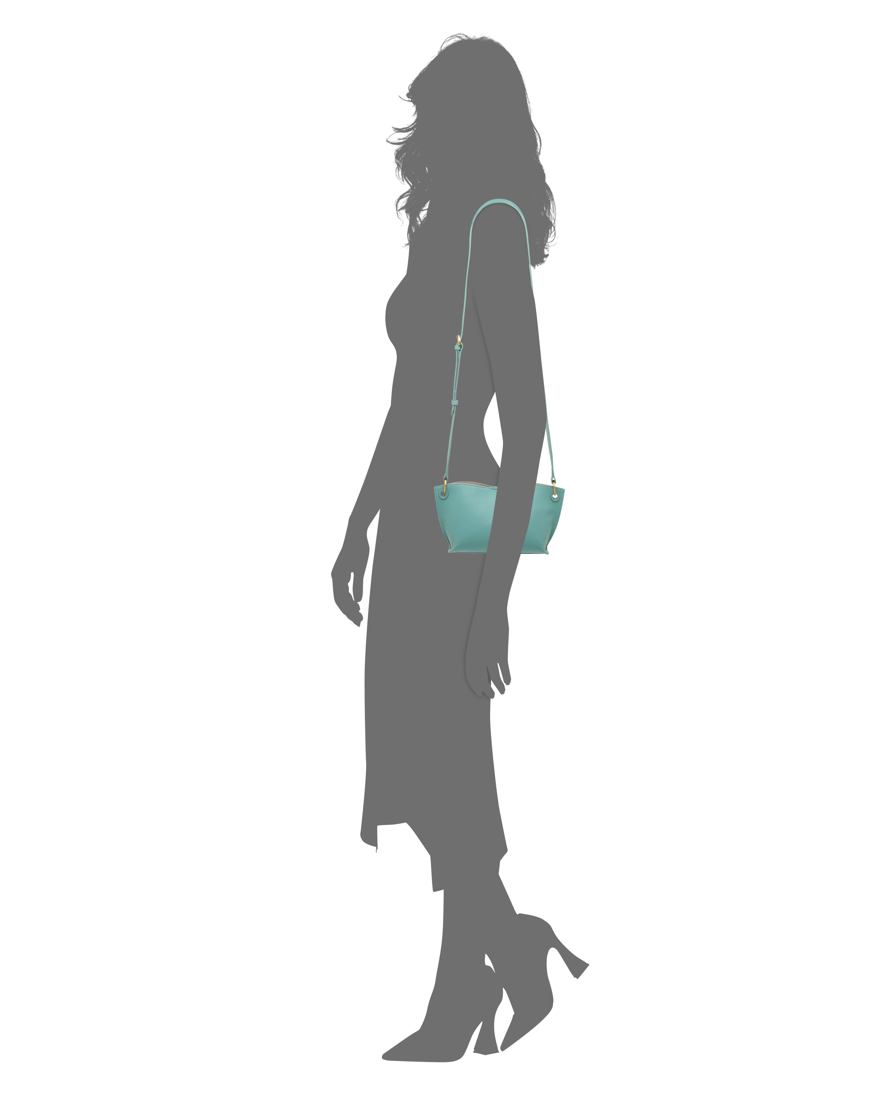 Silhouette of a woman in a mid-length dress and high heels, carrying the Vince Camuto Ellah Crossbody Bag with a long strap over her shoulder.