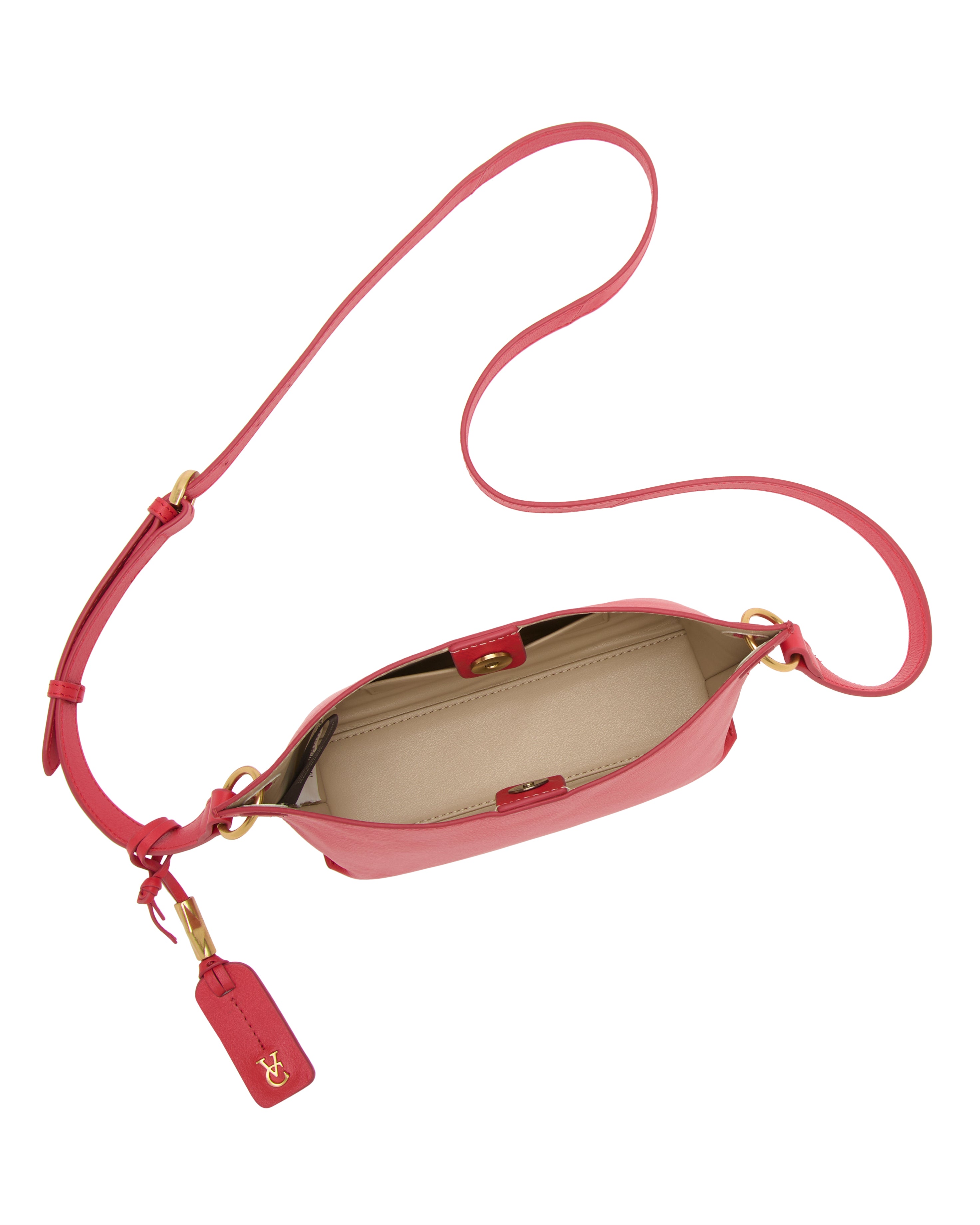 Top view of the Vince Camuto Ellah Crossbody Bag in pink leather, featuring a long adjustable strap, gold-tone hardware, beige interior, and a matching pink keychain with gold initials on the handle.
