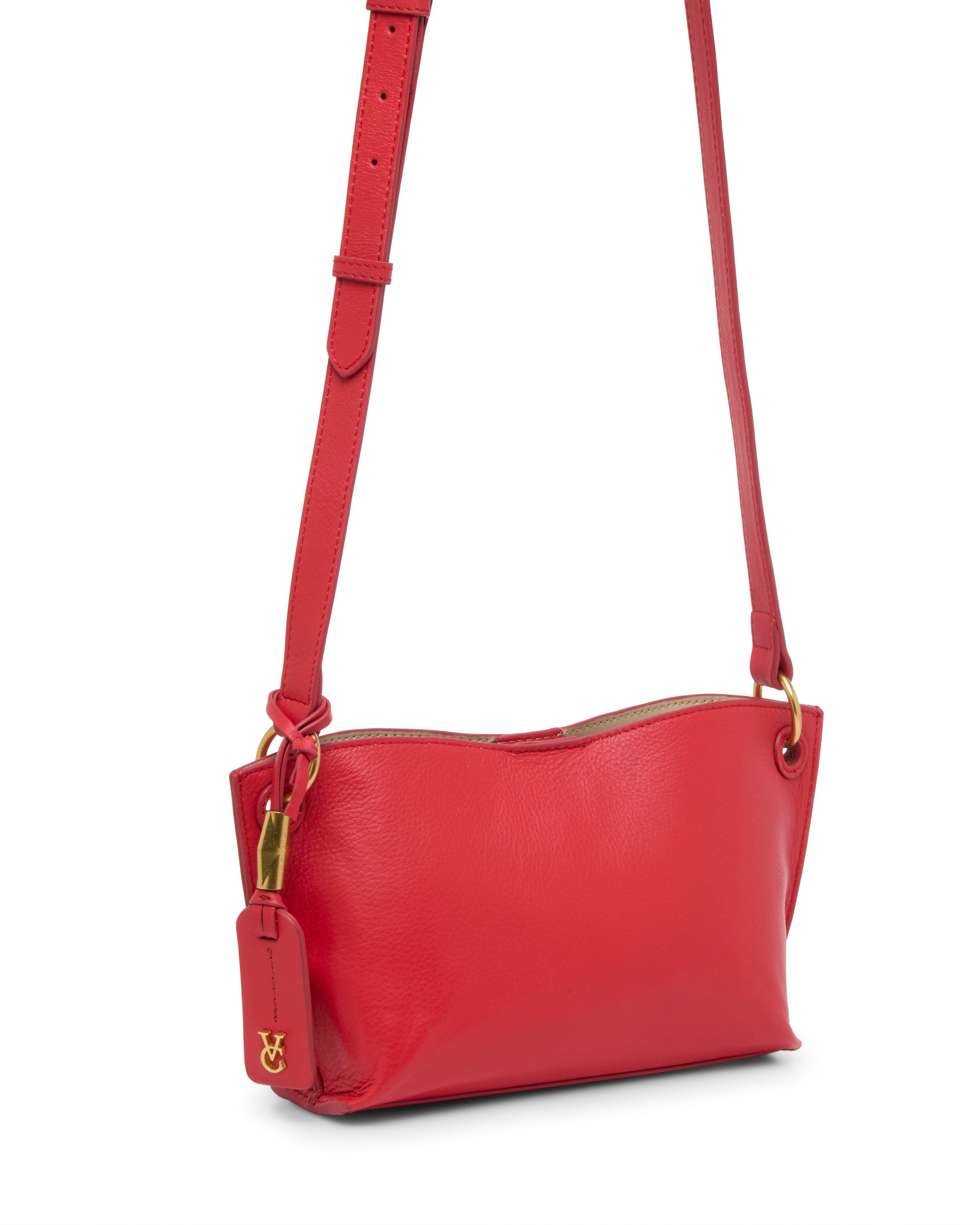The Ellah Crossbody Bag by Vince Camuto is a small, bright red leather bag with a gold clasp, adjustable strap, and matching red tag with a gold logo, displayed against a white background.