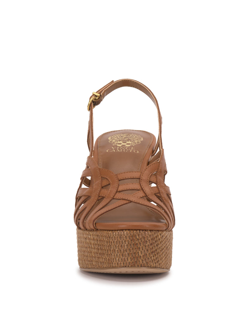 Front view of the Elody Wedge Sandal by Vince Camuto—a tan, open-toe platform with a woven wedge, crisscross leather straps, and an ankle strap finished with a small gold buckle.