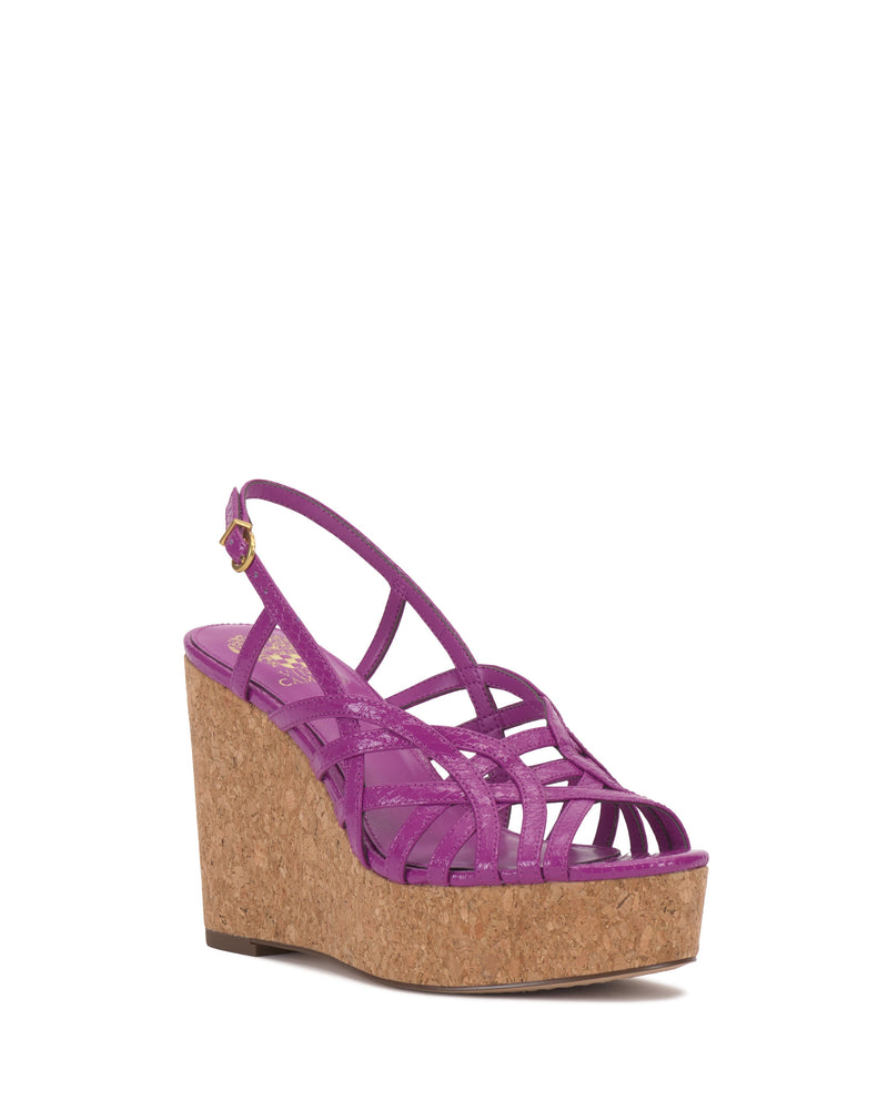 The Vince Camuto Elody Wedge Sandal features a purple strappy upper, cork wedge heel, and ankle buckle strap, displayed on a white background.