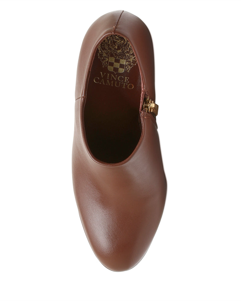 Top view of a brown leather Vince Camuto Elvin Bootie featuring a gold side zipper detail and a subtle platform sole, set against a white background.