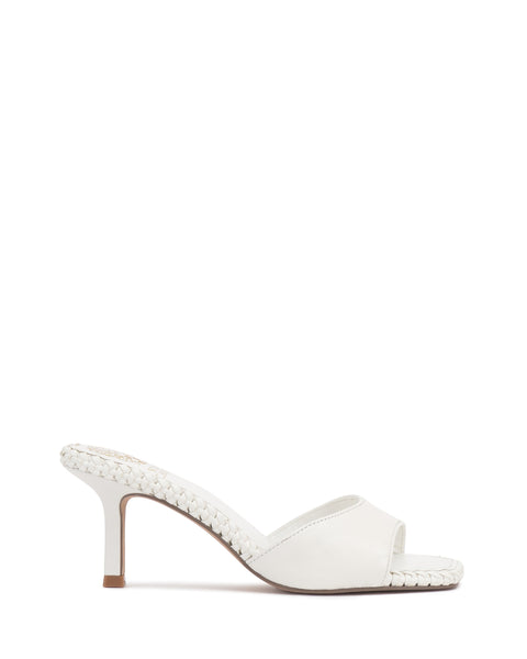 The Emmla Mule by Vince Camuto is a modern white heeled sandal with braided edge details, an open toe, and a mid-height stiletto heel. Light brown sole and heel tip add contrast, making it a standout in trendy women's footwear.
