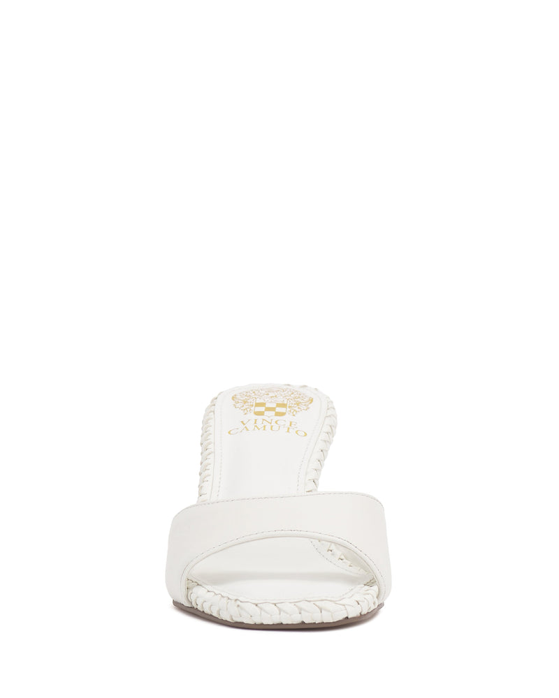 Front view of the Emmla Mule by Vince Camuto—a white open-toe sandal with a single strap and braided edges. A gold logo decorates the insole, highlighting this modern, elegant footwear against a plain white background.