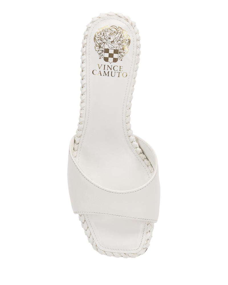 The Emmla Mule by Vince Camuto is a modern white sandal with a square open toe, braided sole trim, and single wide front strap. Gold brand logo accents the insole—making it a chic choice for trendy women’s footwear.