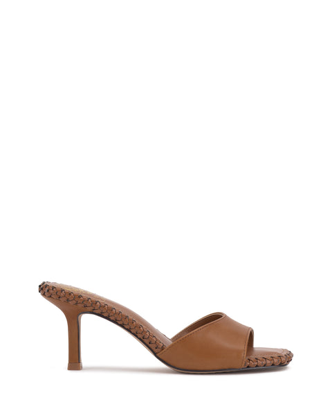 The Vince Camuto Emmla Mule is a brown open-toe sandal with a medium stiletto heel, showcasing modern elegance and braided details along the upper edge and sole.