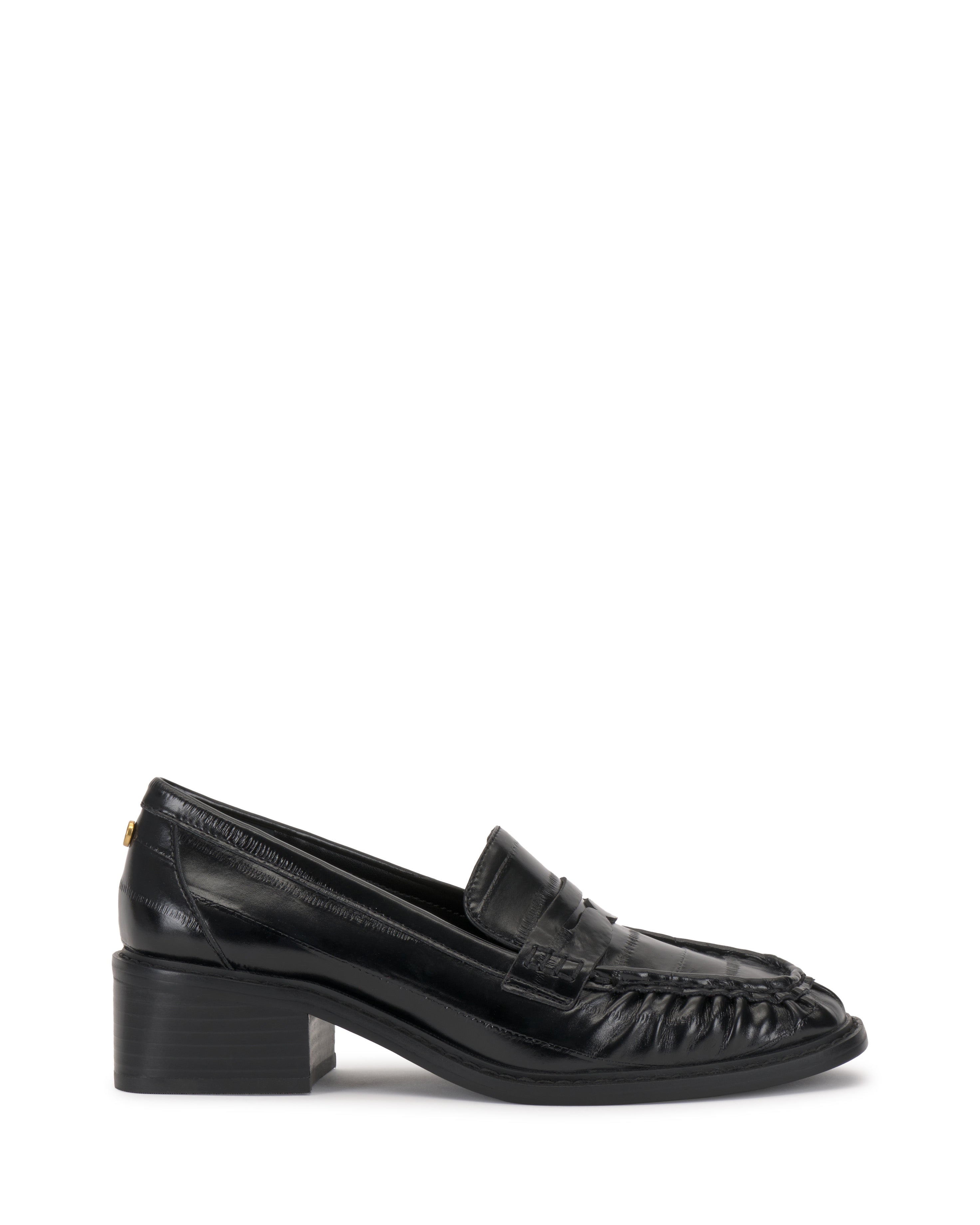 The Vince Camuto Eshnie Block Heel Loafer is a black loafer with a low block heel, penny strap detail, and stitched toe accents, shown in side profile on a white background.