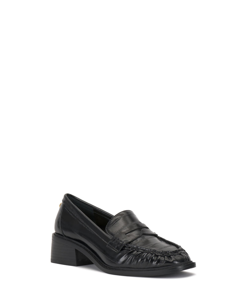 The Vince Camuto Eshnie Block Heel Loafer showcases black leather with a low block heel, rounded toe, and stitched front detail, shown on a white background.