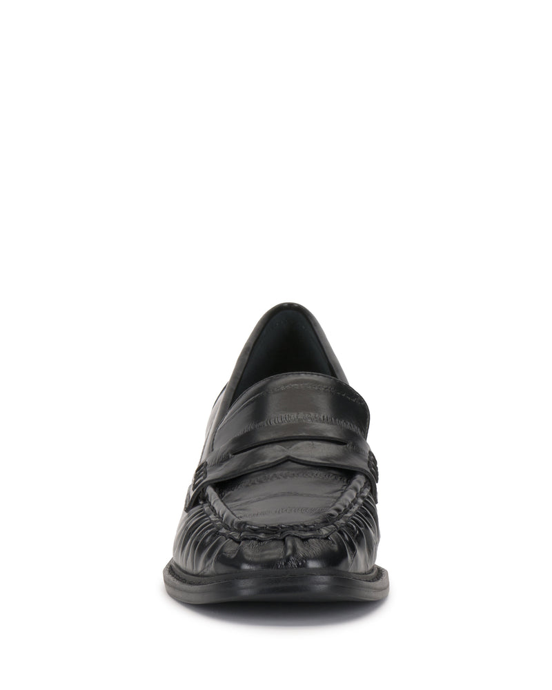 Front view of the Vince Camuto Eshnie Block Heel Loafer in black leather, showcasing a moccasin-style toe, detailed stitching, and a chic block heel against a white background.
