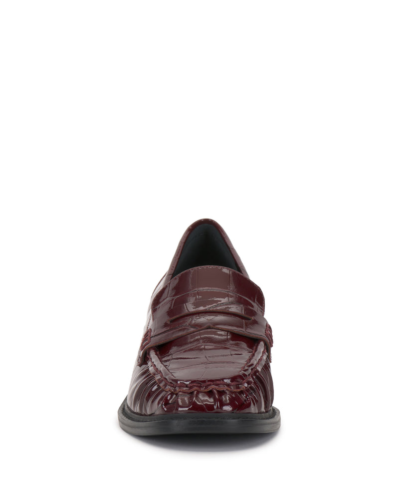 Front view of the Eshnie Block Heel Loafer by Vince Camuto in burgundy, featuring a shiny textured finish, detailed toe stitching, and a low black sole on a white background.