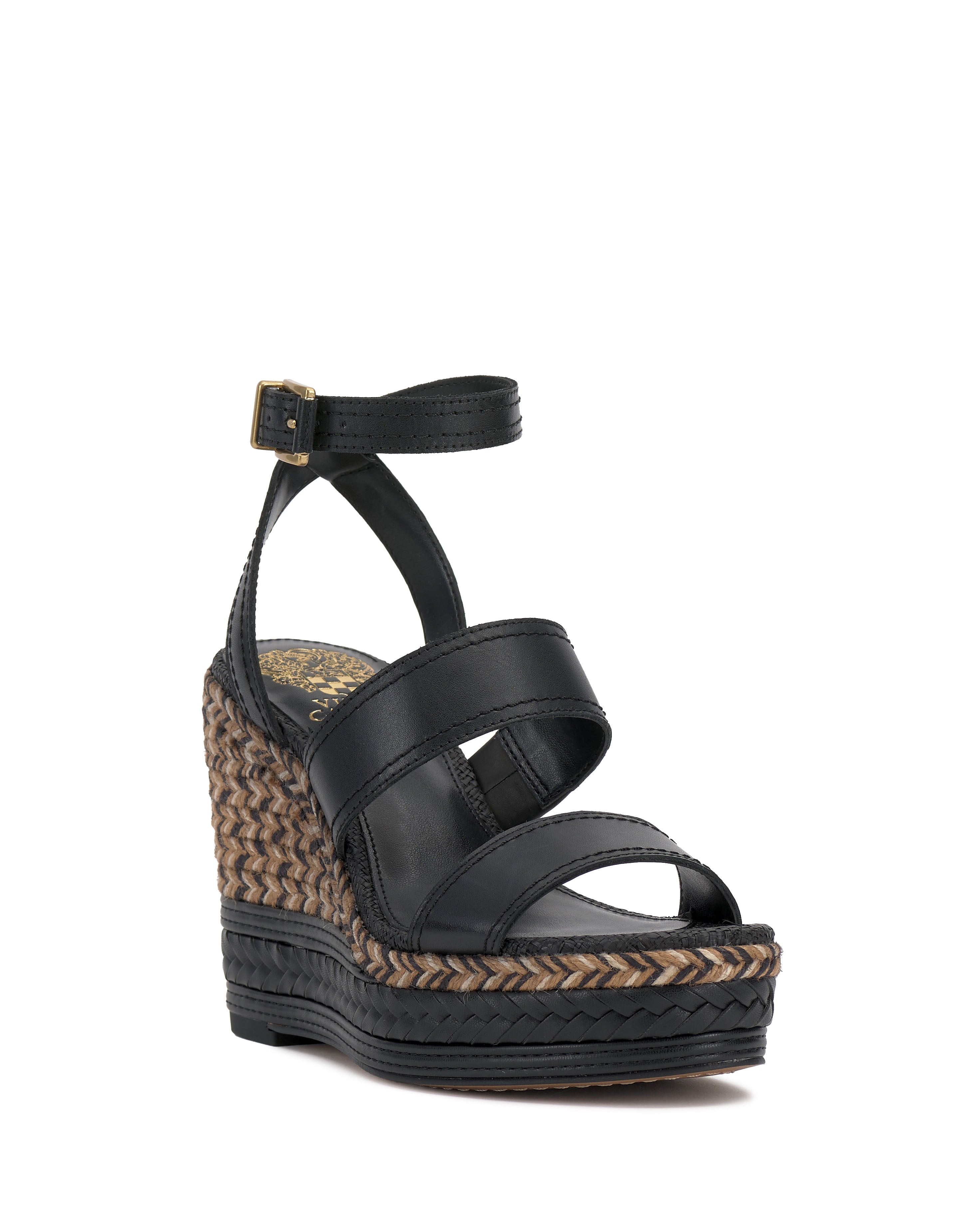 The Vince Camuto Esmia Espadrille Wedge Sandal features two black front straps, an ankle buckle strap, and a tan-and-black woven espadrille heel with a braided platform sole for textured style.