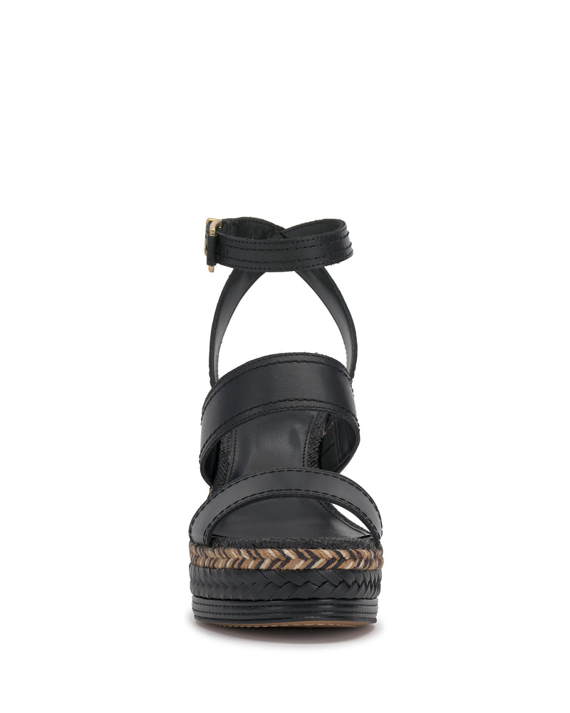 The Vince Camuto Esmia Espadrille Wedge Sandal features black crisscross front straps, an ankle strap, and a braided platform espadrille heel, shown from the front on a white background.