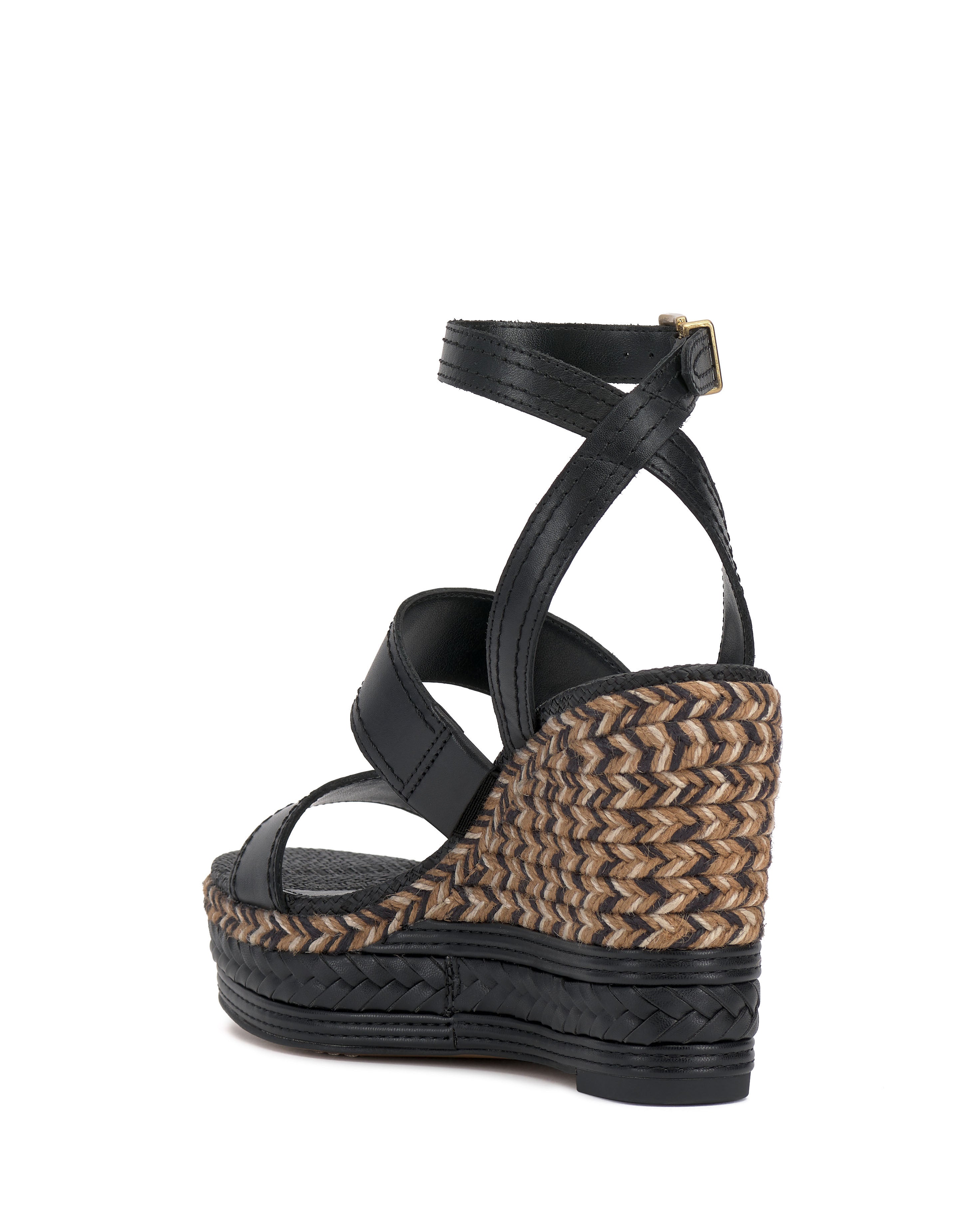 The Vince Camuto Esmia Espadrille Wedge Sandal features black straps, an ankle buckle, and a braided brown and tan platform heel. Displayed against a white background.
