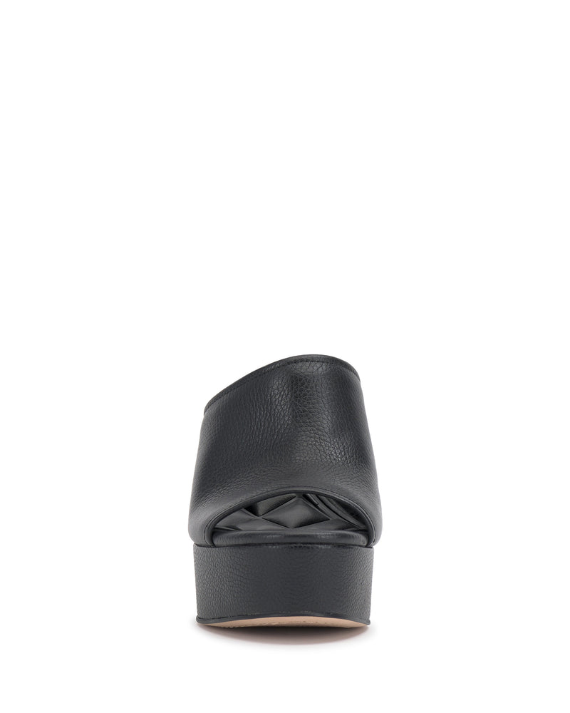 The Vince Camuto Etta Wedge Sandal is a black, open-toe shoe with a Y2K-inspired textured leather upper, a single band design, and a low leather wedge heel, shown from the back against a white background.