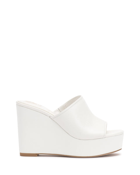 The Vince Camuto Etta Wedge Sandal is a Y2K-inspired white mule with an open toe, textured upper, and chunky platform sole, shown in profile against a white background.