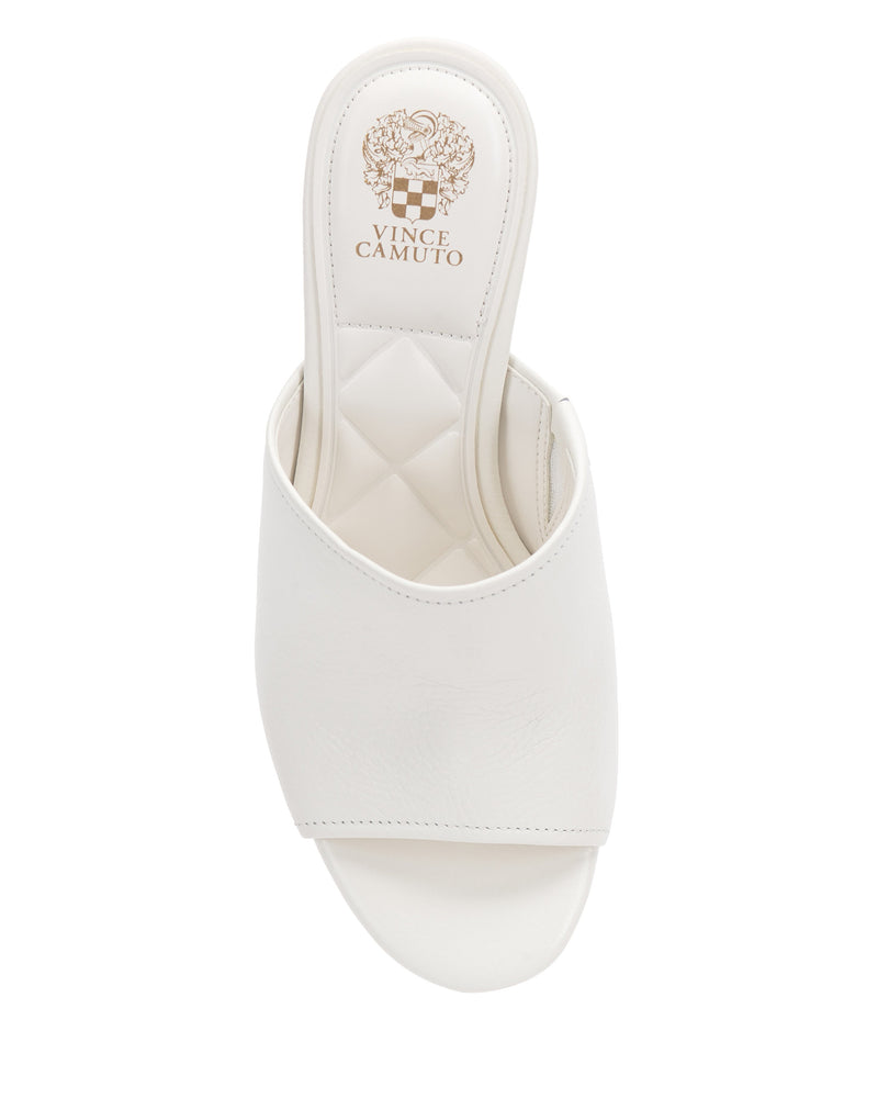 The Vince Camuto Etta Wedge Sandal is a white, open-toe slip-on with a single band, quilted footbed, leather wedge heel, and the Vince Camuto logo on the insole.