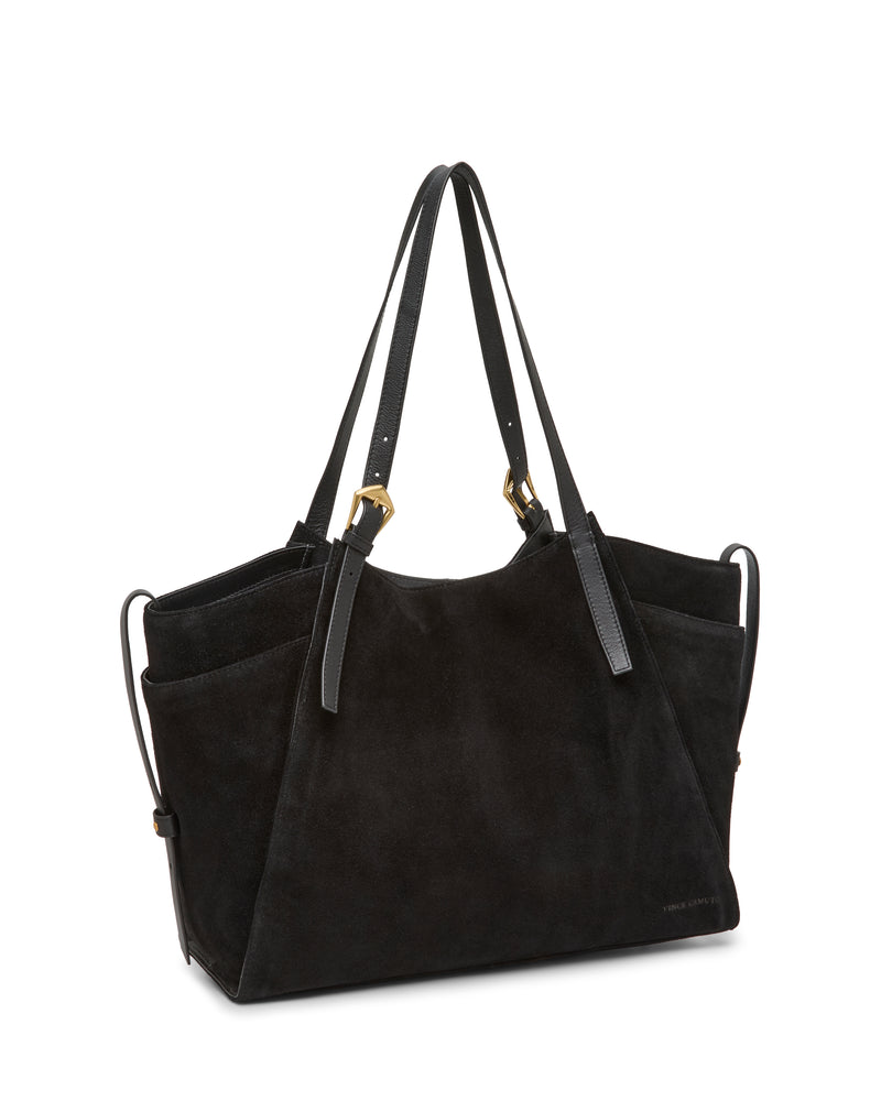 The Vince Camuto Faey Tote Bag, crafted in black suede with two long leather handles, gold-tone hardware, and convenient side pockets, is shown standing upright against a white background.