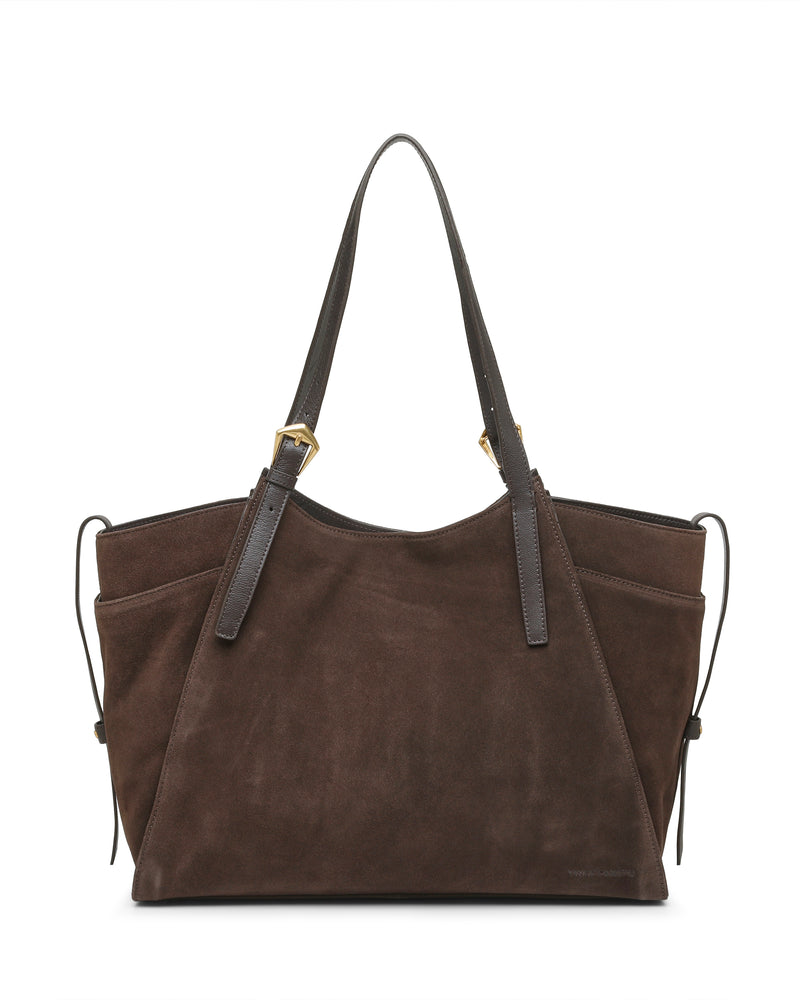 The Faey Tote Bag by Vince Camuto features brown suede construction with dark leather straps, gold-tone hardware, and side drawstring accents. Its structured silhouette is finished with visible stitching along the edges.