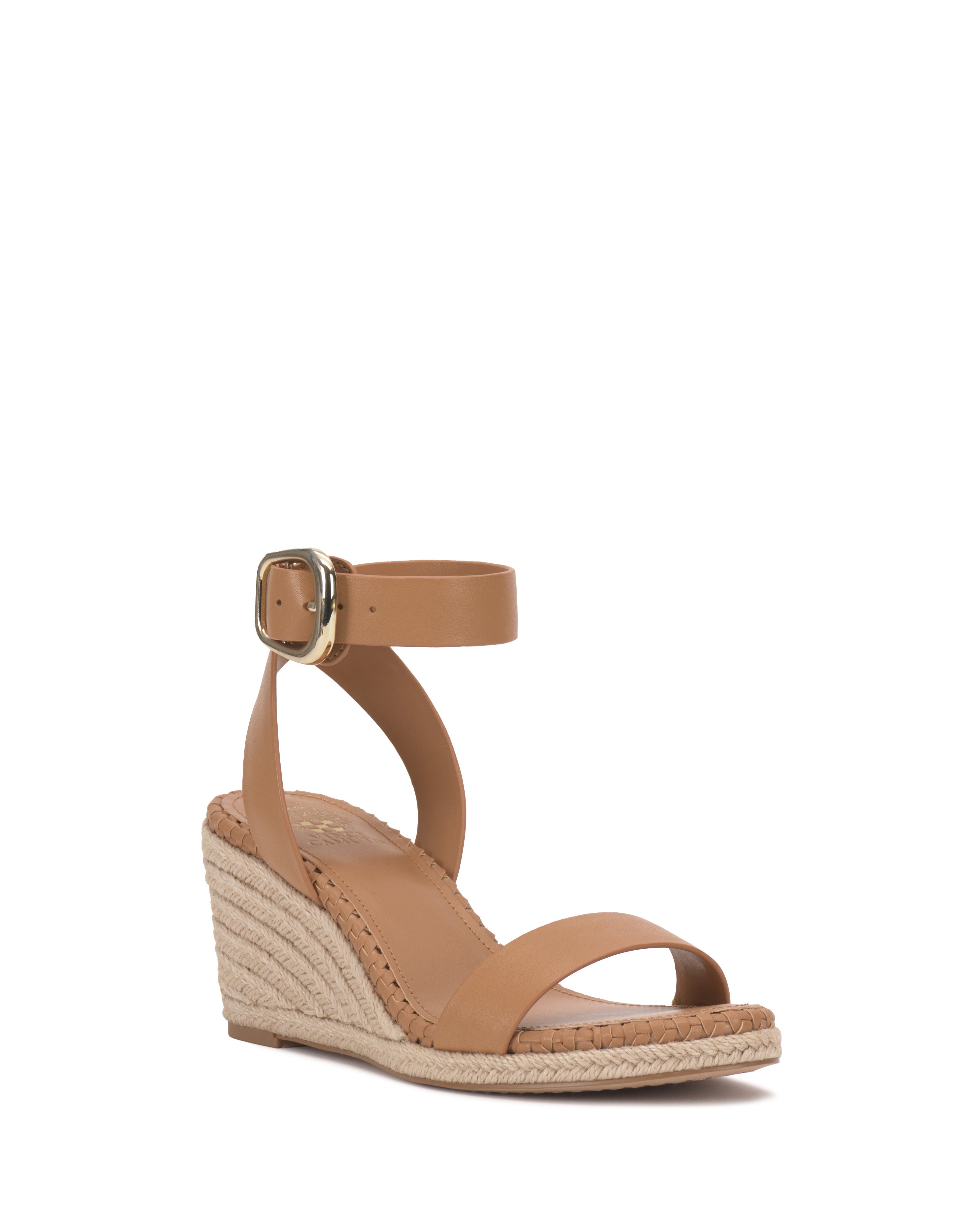 The Vince Camuto Fainel Espadrille Wedge Sandal features a strappy tan upper, bold buckle closure, braided espadrille wedge heel, and open toe design, displayed on a white background.