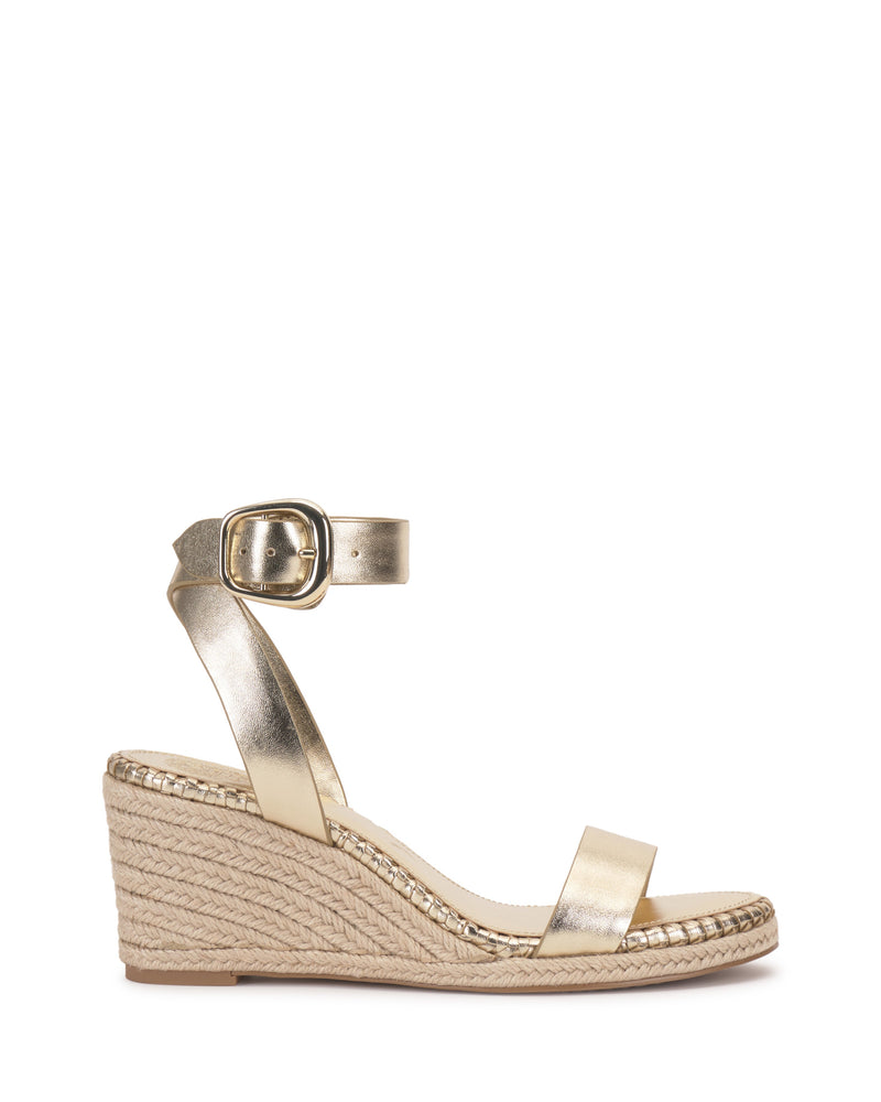 The Vince Camuto Fainel Espadrille Wedge Sandal is a gold metallic wedge with an ankle strap, bold buckle, braided platform sole, and open toe, shown on a white background—perfect as a chic summer sandal.