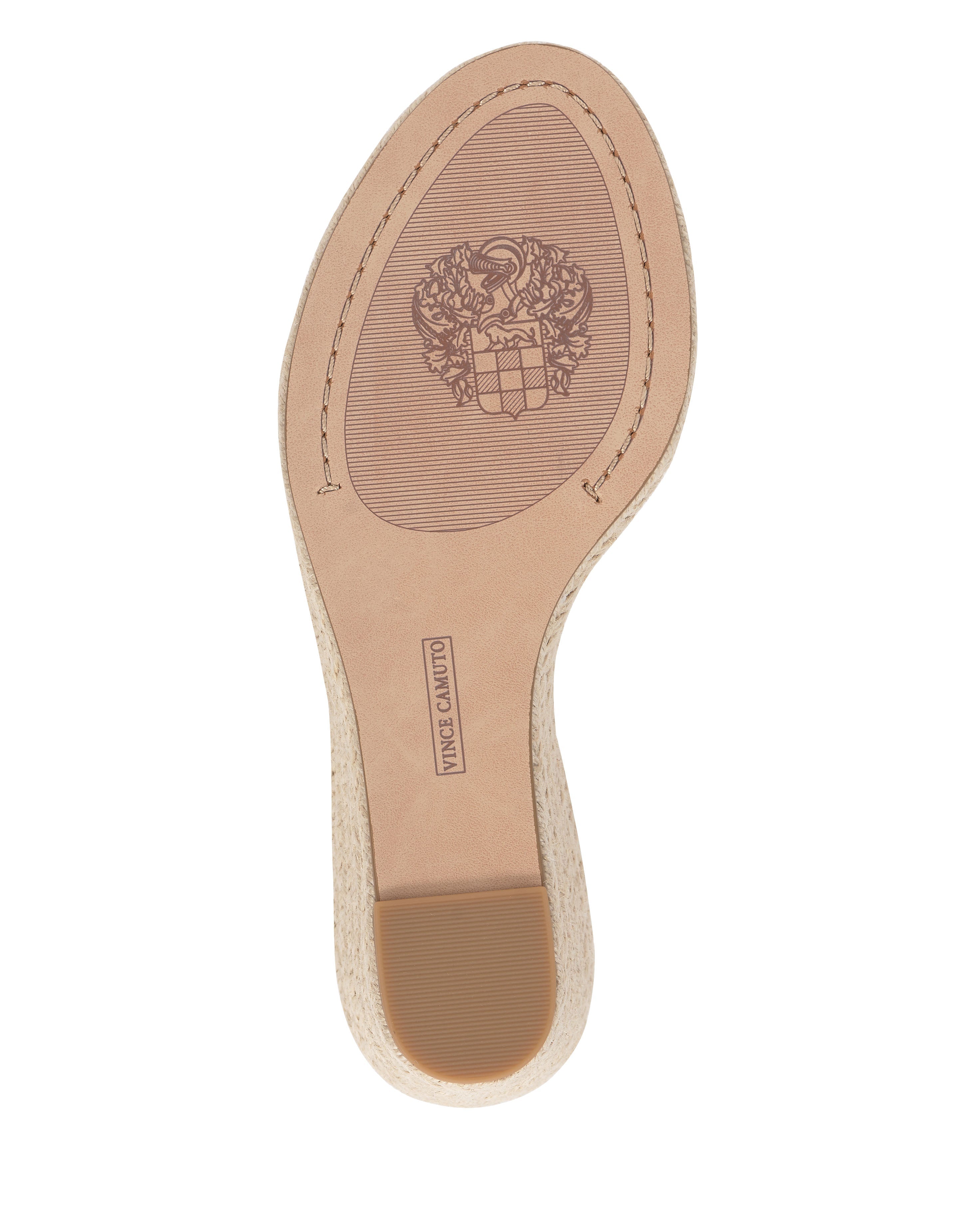 The image features the sole of the Felia Espadrille Wedge Sandal by Vince Camuto, showing a crest design and brand stamp, plus a textured non-slip rubber heel section that accents its espadrille wedge style.