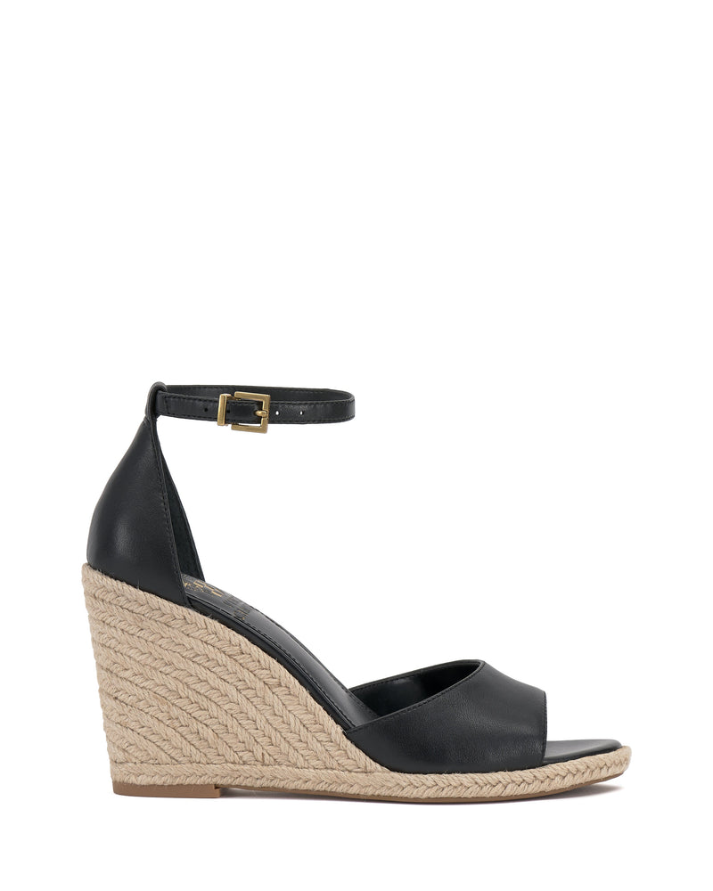 The Vince Camuto Felyn Espadrille Wedge Sandal is a black open-toe design with an ankle strap and buckle, featuring a stylish woven espadrille heel.
