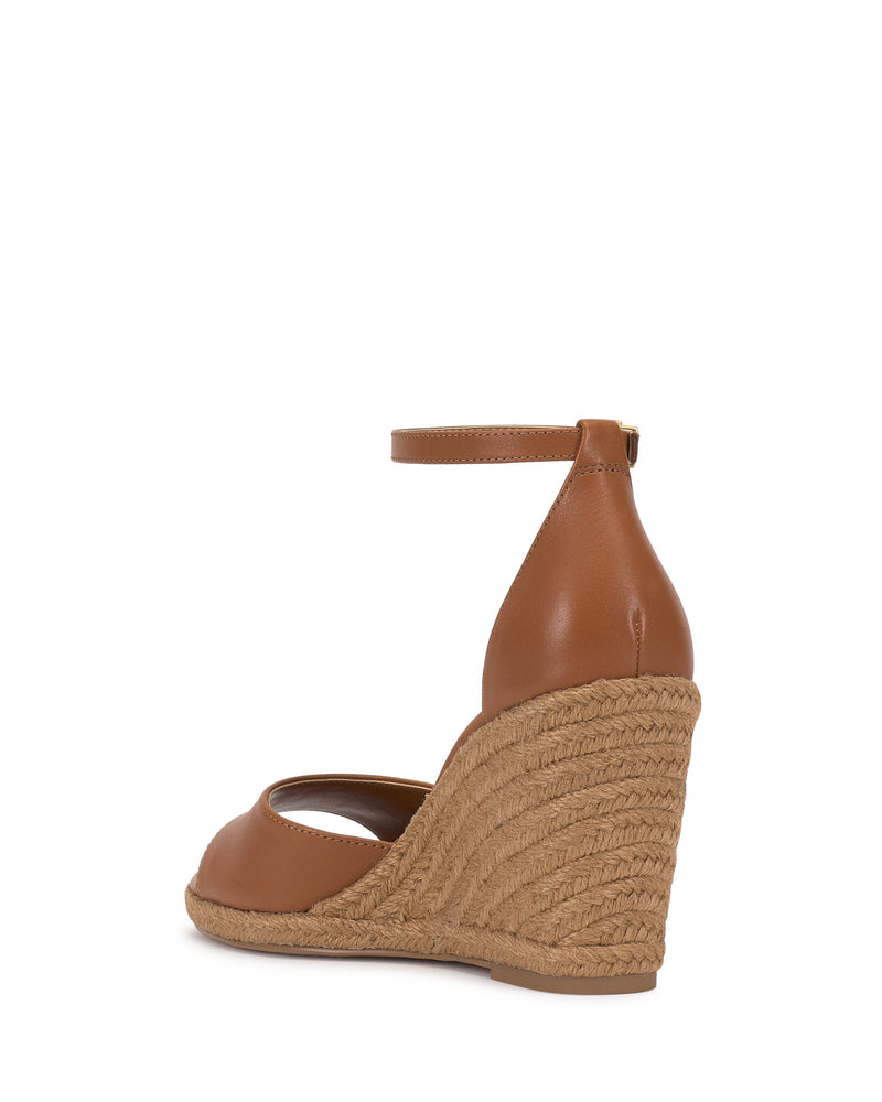 The Vince Camuto Felyn Espadrille Wedge Sandal features a brown, woven-texture wedge with an ankle strap, closed heel, braided jute platform, and classic espadrille heel; shown from the back.