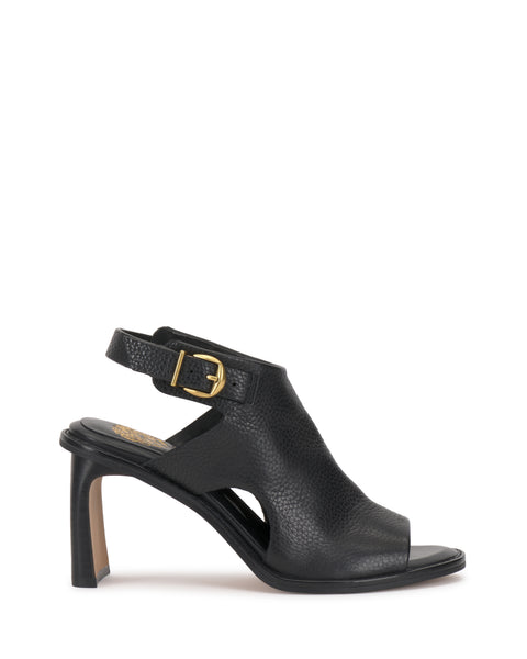 The Fezisha Sandal by Vince Camuto is a black leather high-heeled sandal featuring an open toe, cut-out sides, gold buckle ankle strap, and a sturdy, slightly curved heel.