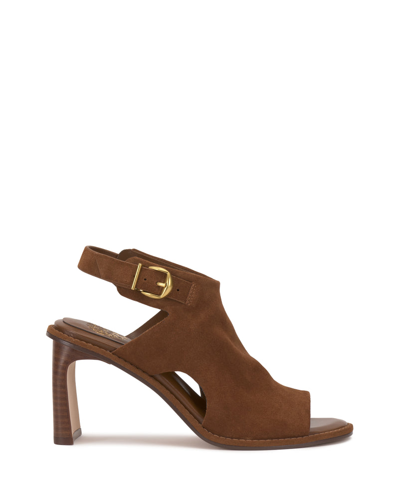 The Vince Camuto Fezisha Sandal features brown suede, an open toe, cutout sides, a slingback strap with gold buckle, and a stacked high heel. Displayed on a white background.
