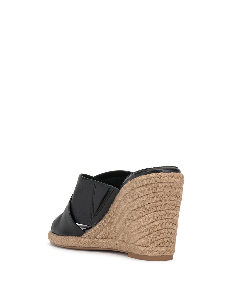 The Vince Camuto Fisella Espadrille Wedge Sandal features black leather, an espadrille platform, braided jute heel, and open back—all shown from the rear view on a white background.