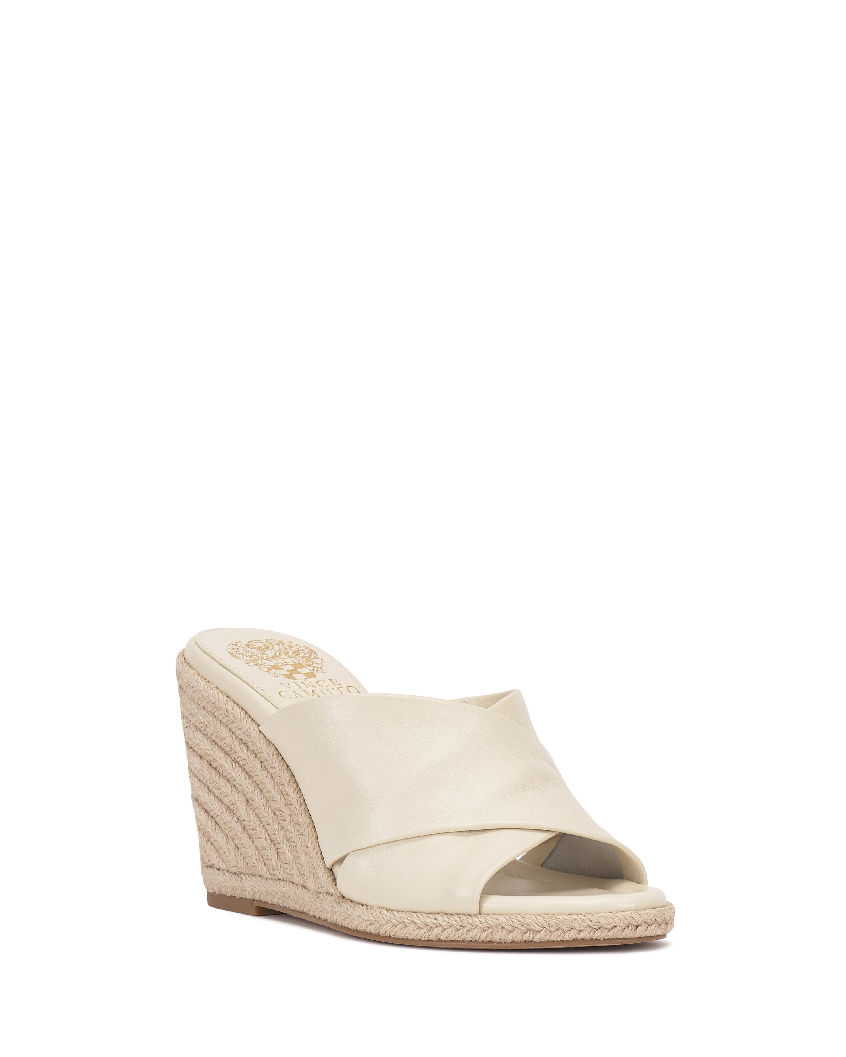 The Vince Camuto Fisella Espadrille Wedge Sandal features a cream leather upper, open toe, and woven espadrille platform with an easy slip-on design, shown on a plain white background.