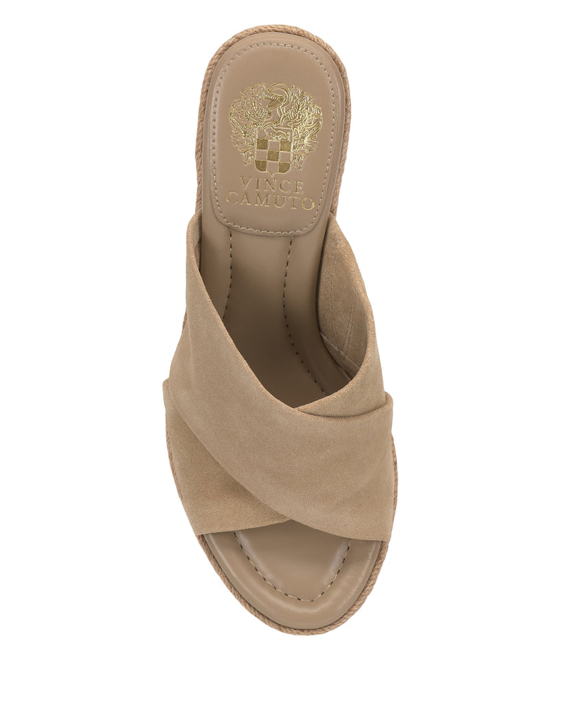 The Vince Camuto Fisella Espadrille Wedge Sandal features tan crisscross suede straps, a cushioned insole, slip-on design, and gold Vince Camuto logo on the heel pad.