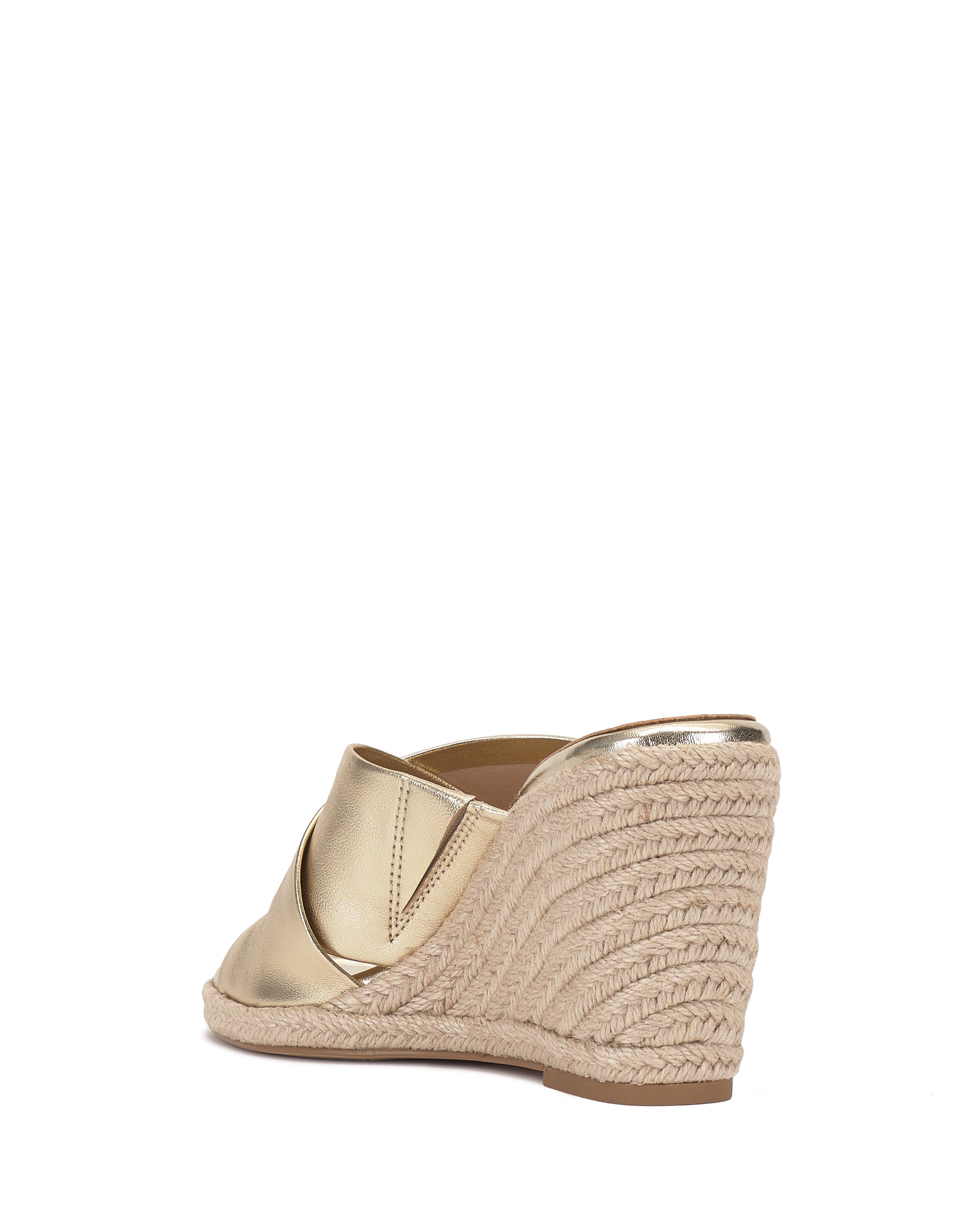 The Vince Camuto Fisella Espadrille Wedge Sandal features a gold finish, open back, slip-on style, and braided jute platform heel, shown from an angled rear view on a white background.