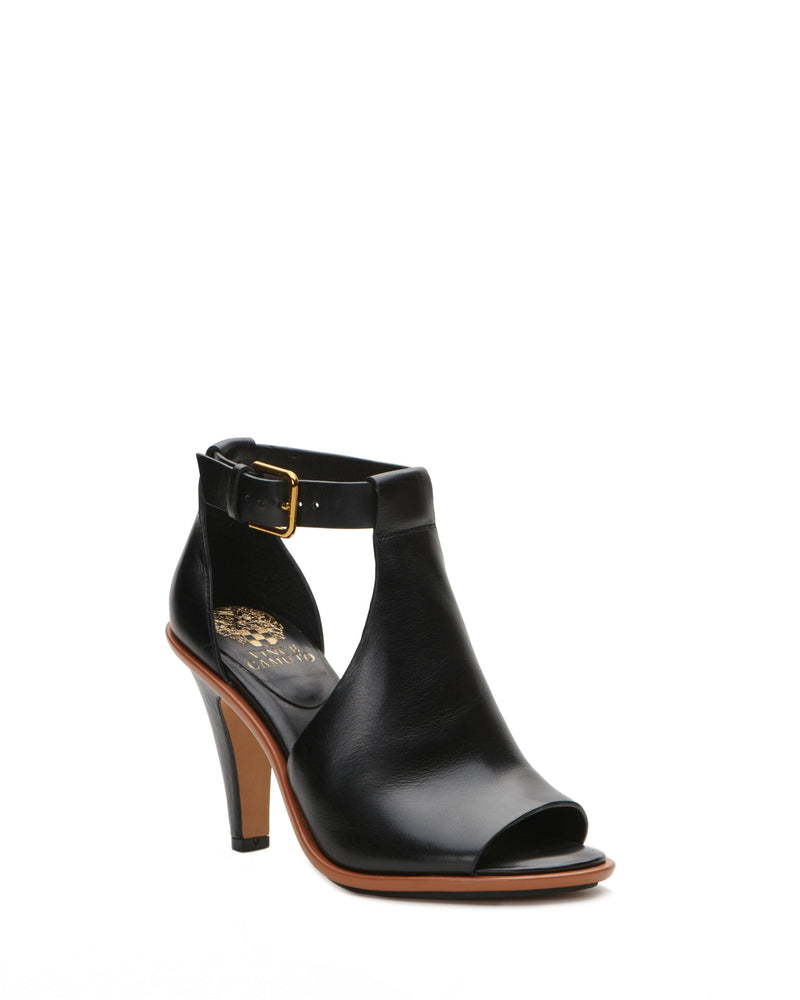 The Frasper Shootie by Vince Camuto is a black leather peep-toe high heel with an ankle strap and gold buckle, featuring a cutout design, cushioned footbed, and mid-height stiletto heel, displayed against a plain white background.