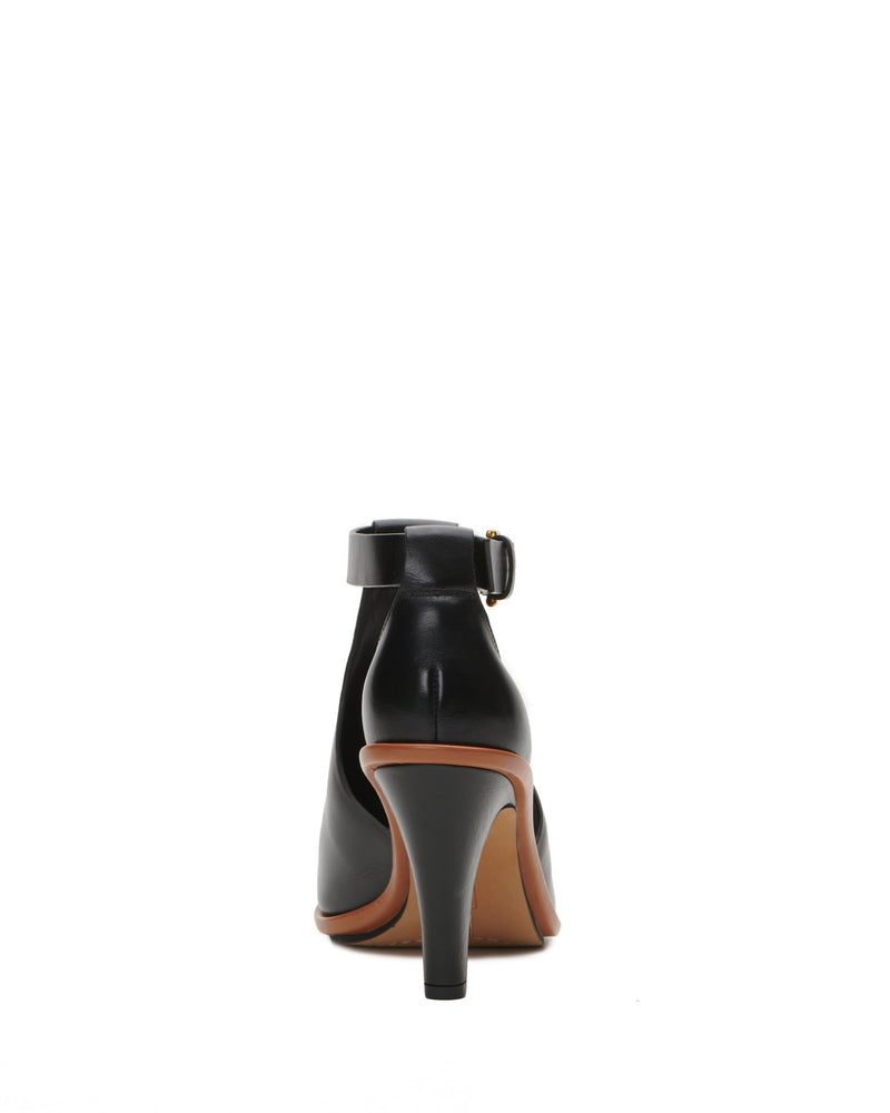 The Vince Camuto Frasper Shootie is a black high-heeled shoe with an ankle strap and a brown sole, showcased from the back against a white background, and features a cushioned footbed for enhanced comfort.