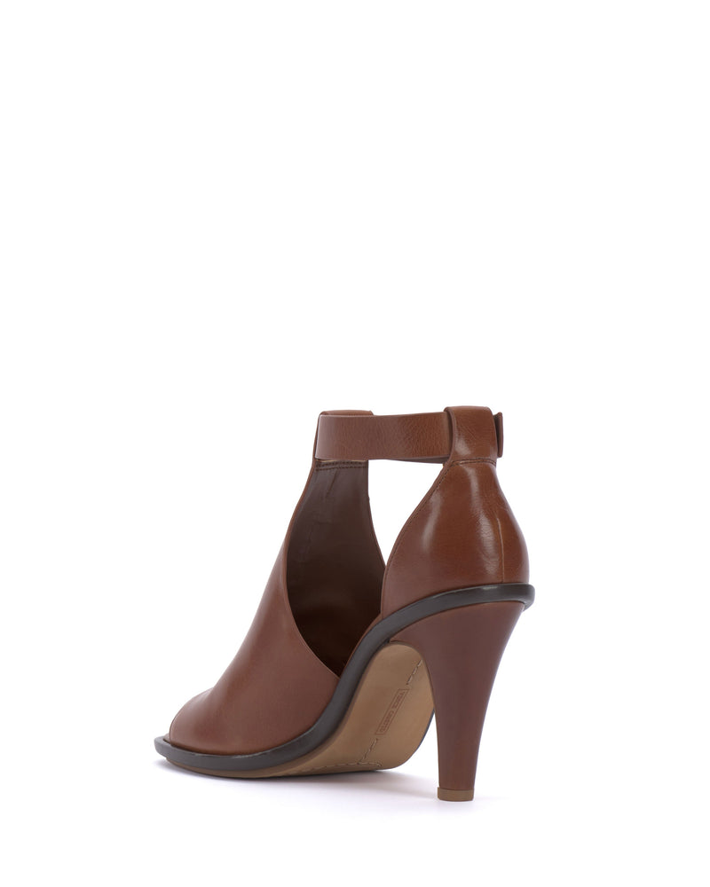 The Vince Camuto Frasper Shootie is a brown leather high-heeled peep-toe sandal featuring an open side and ankle strap, shown from the back left against a white background.