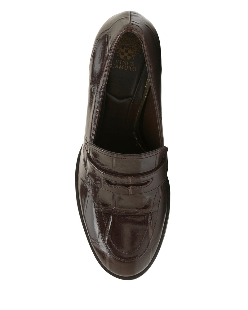 Top view of a single dark brown Vince Camuto Geanna Pump with a block heel, featuring a penny strap and stitching details, photographed on a white background.