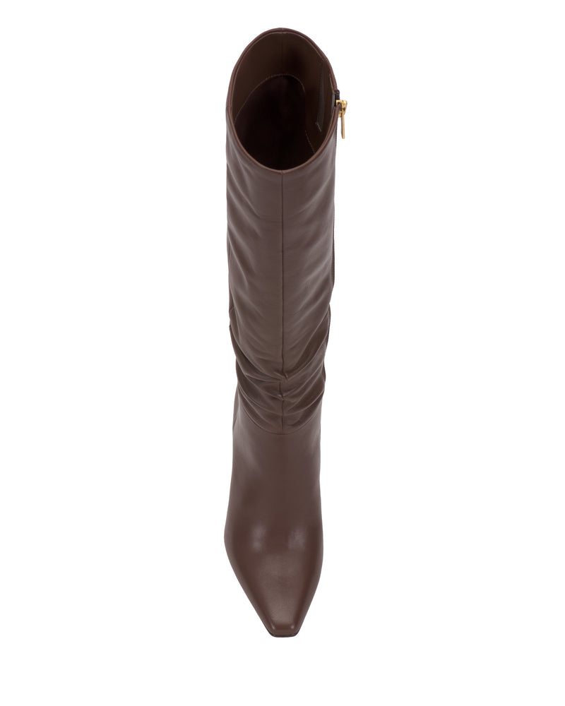 A top view of the Vince Camuto Genisa Narrow Calf Slouchy Knee High Boot in brown leather, featuring a pointed toe and a gold side zipper, displayed against a white background.