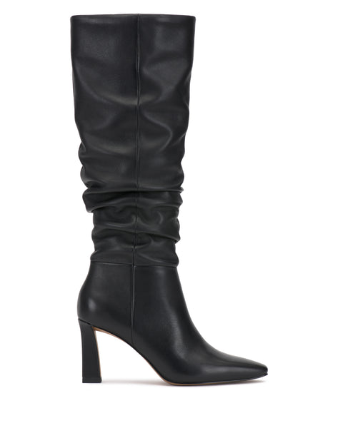 The Genisa Wide Calf Slouchy Knee High Boot by Vince Camuto is a black, high-heeled boot with a pointed toe and a slightly slouched leather shaft, displayed in side profile against a white background.