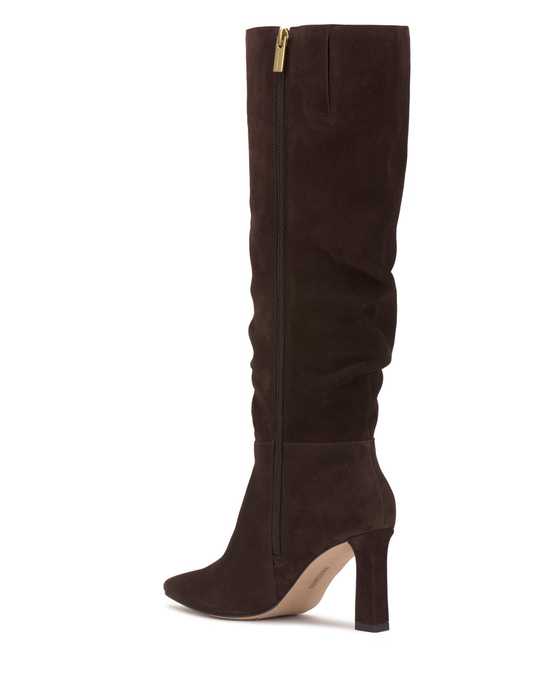 The Genisa Wide Calf Slouchy Knee High Boot by Vince Camuto, featuring dark brown suede, a pointed toe, side zipper, and high heel, is displayed against a white background.