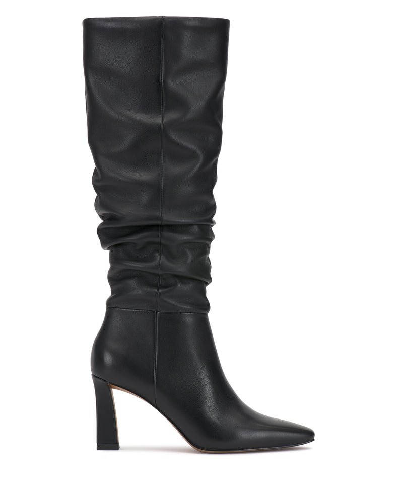 The Genisa Slouchy Knee High Boot by Vince Camuto is a black, knee-high boot with a pointed toe, heeled design, and slouchy shaft, shown in side view against a white background.