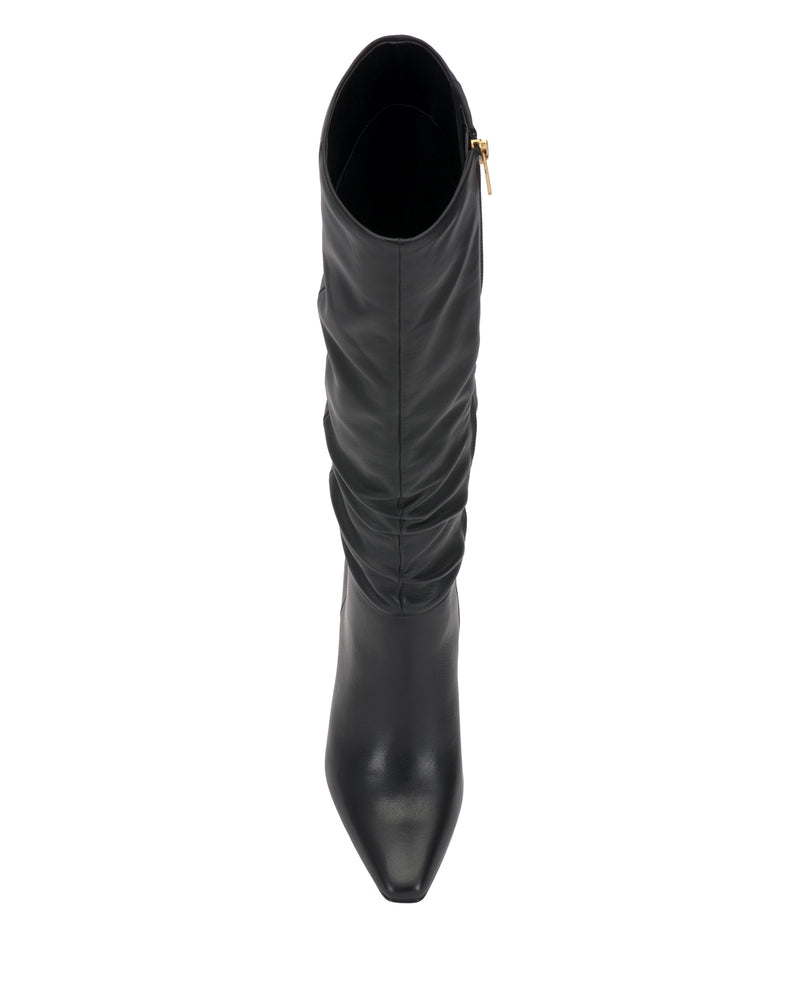 The Genisa Slouchy Knee High Boot by Vince Camuto is a black leather boot featuring a pointed toe and a gold side zipper, shown from above against a white background.