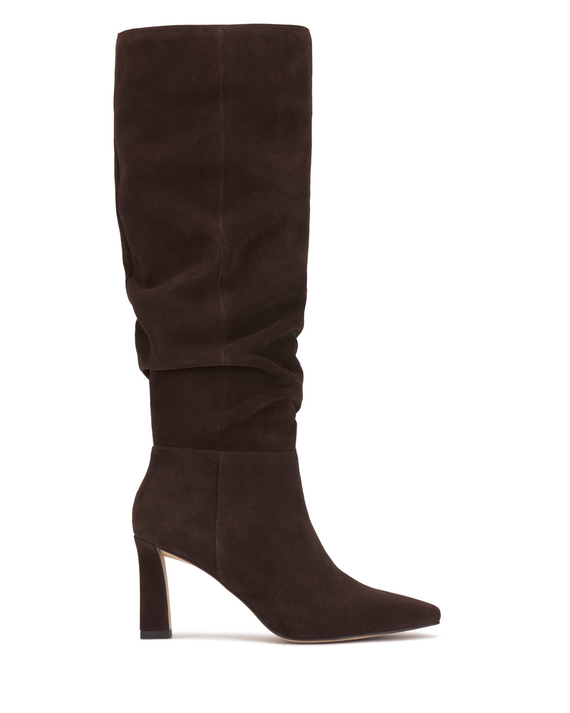 Side view of the Vince Camuto Genisa Slouchy Knee High Boot in dark brown suede, featuring a tall slouchy silhouette, pointed toe, and high block heel, set against a white background.