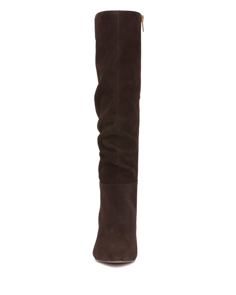 The Vince Camuto Genisa Slouchy Knee High Boot is a tall, dark brown suede boot with a subtle slouch effect, shown from the front against a white background.