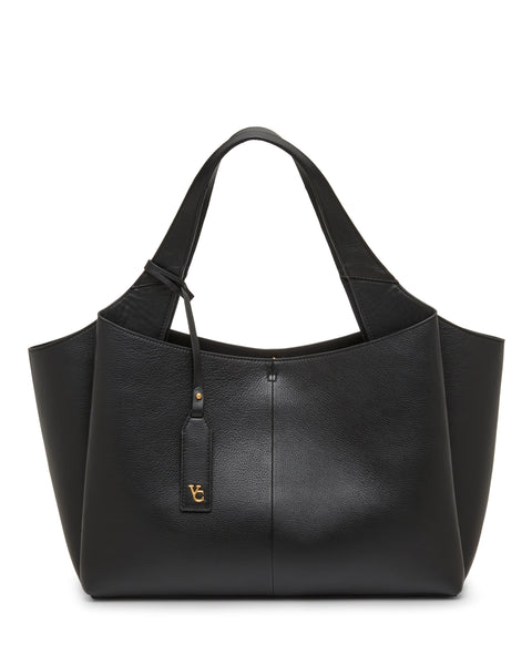 The Gilda Tote Bag by Vince Camuto is a spacious black leather tote featuring wide handles and a gold-tone logo tag, shown against a white background.