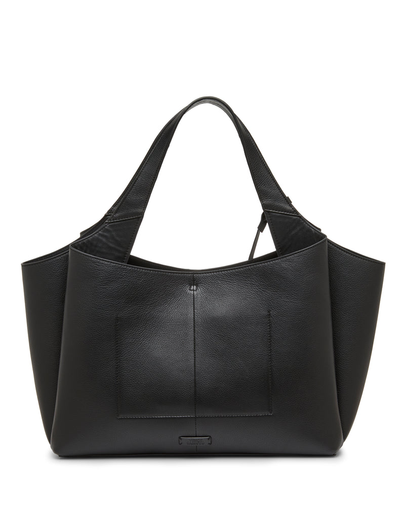 The Gilda Tote Bag by Vince Camuto features black leather with double handles, a front exterior pocket, and a minimalist, structured silhouette. It has a smooth finish and is accented by a small rectangular logo plate at the bottom center.